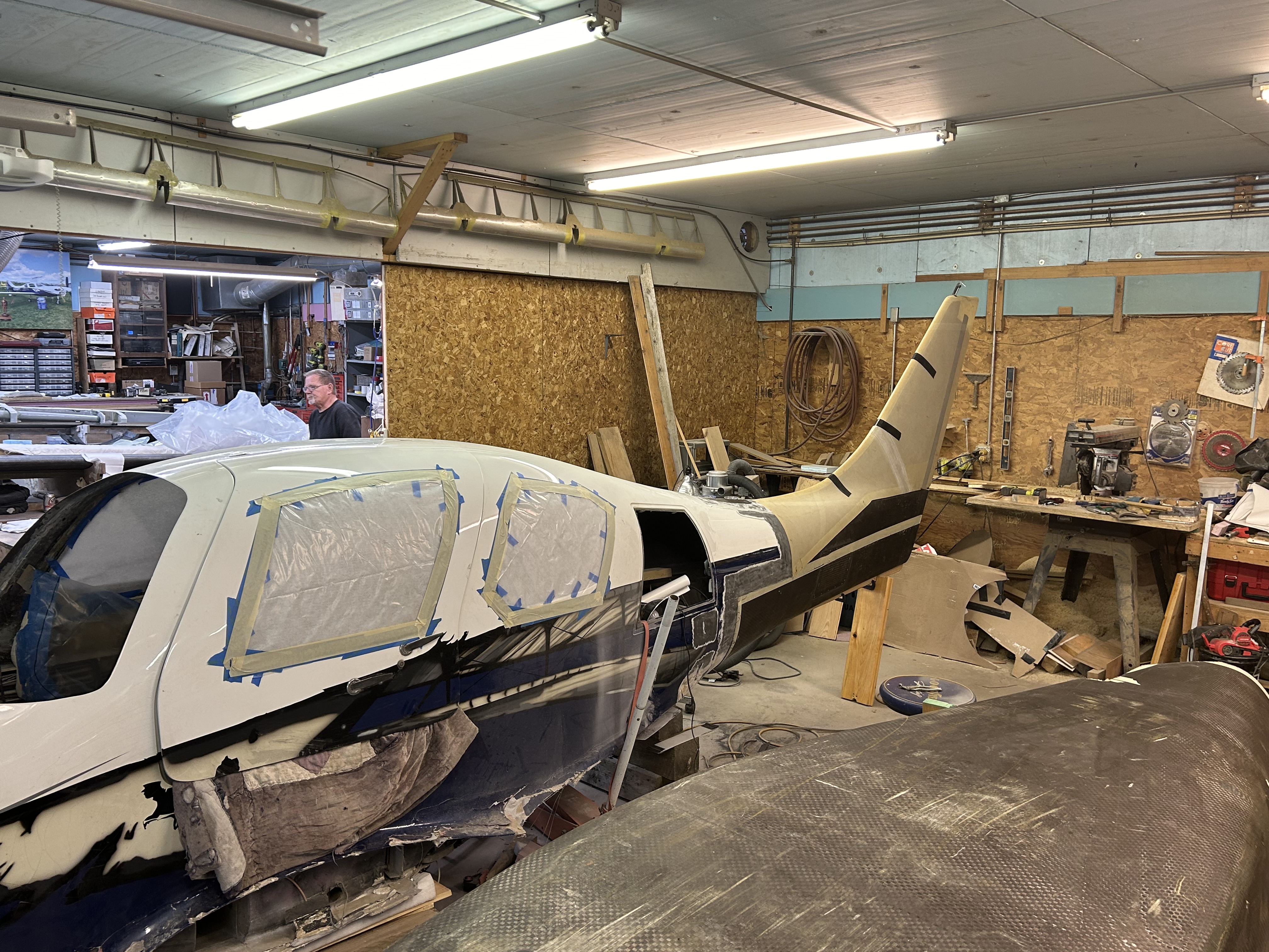 Repair section of lower fuselage fitted to plane with vertical stabilizer